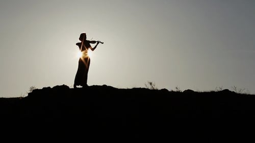 Silhouette of Violinist Playing Beautiful Music at Sunset