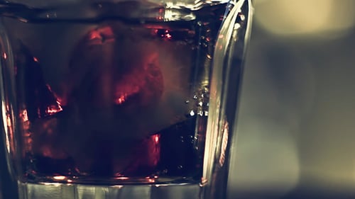 Red Soda Being Poured into Glass of Ice
