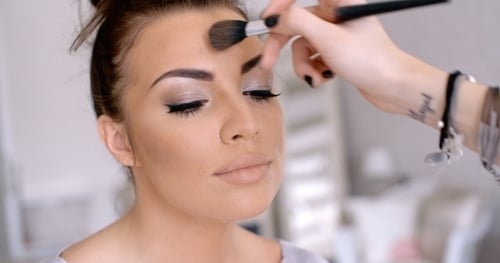 Woman Receiving Professional Makeup Application with Brush