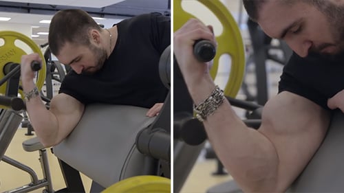 Muscular Man Doing Bicep Curls on Machine in Gym