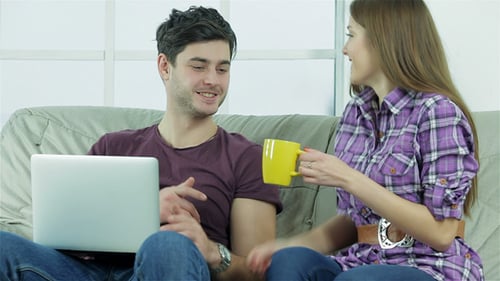 Woman Brings Coffee to Man Using Laptop