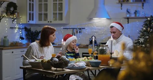 Family Gathered for Christmas Meal in Festive Kitchen