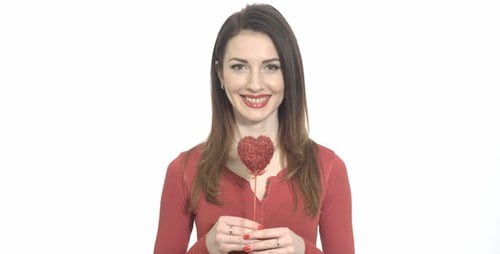 Smiling Woman Holding Heart Winks to Camera