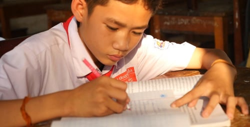 Focused Student Completing Homework in Classroom