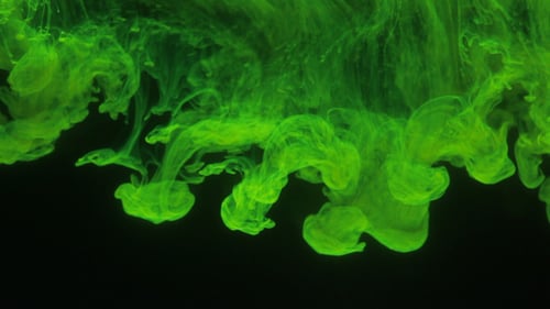 Green Ink Dissolving in Water at Night