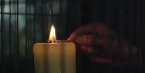Lighting Candle with Match in the Darkness