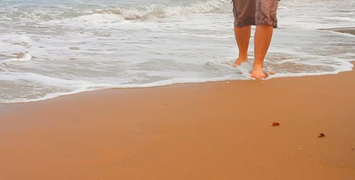 A Man Walks Along a Deserted Beach