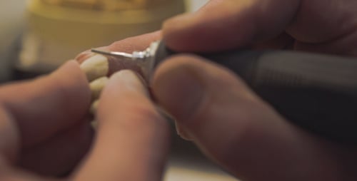 Dental Technician Crafting Implants with Precision Tools