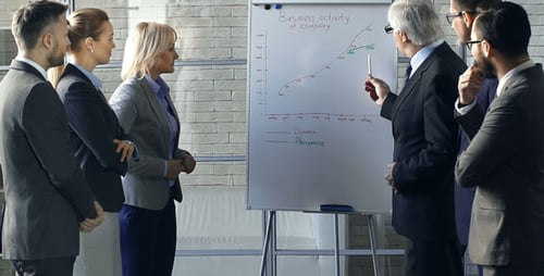 Business Team Discusses Sales Graph in Office