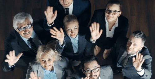 Business People Waving up at Camera in Workplace