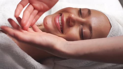 Spa Damen Gesichtsmassage. Gesichtsmassage im Beauty-Spa-Salon. Frau genießt entspannende Gesichtsmassage