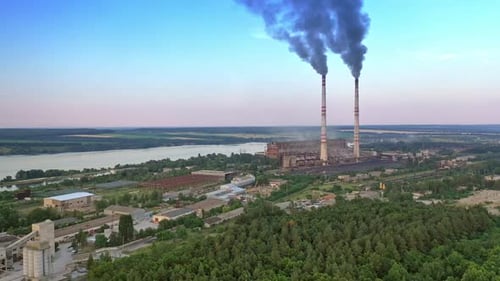 Industrial zone in countryside. Air pollution by smoke coming out of two factory chimneys