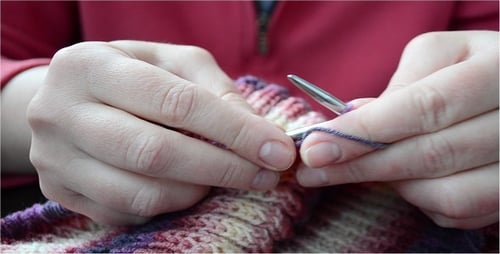 Hands Knitting Yarn with Needles in Close Up
