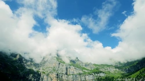 Wolken bewegen sich schnell über Berglandschaft