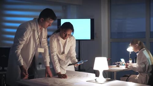 Scientists Working Together in Laboratory at Night