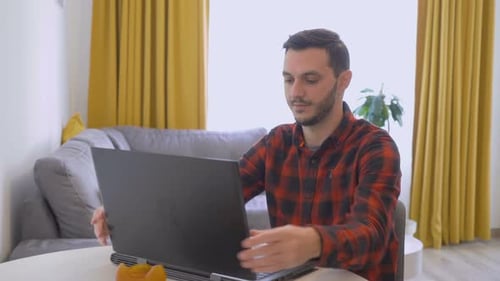 Young Adult Video Calling On Laptop At Home