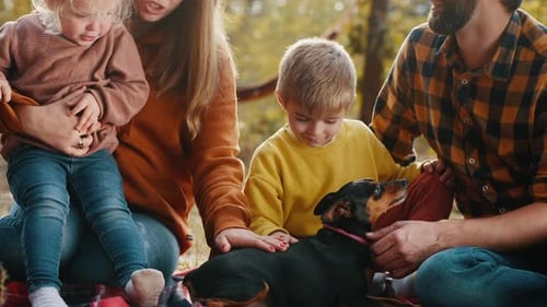 Young Family with Children and a Dog in an Autumn Park