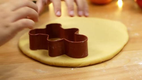 Child Using Cookie Cutter on Dough