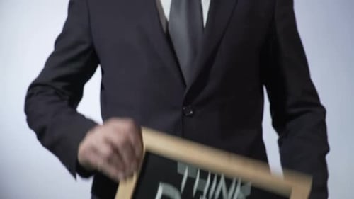 Professional Holding 'Think Big' Chalkboard Sign Close Up