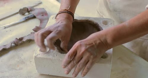 Hands Forming Pottery Inside of Mold
