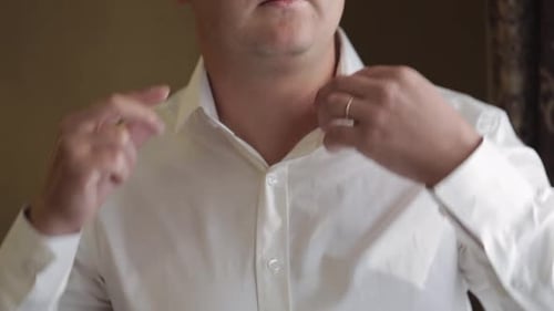 Man Buttons Formal Shirt Before a Wedding