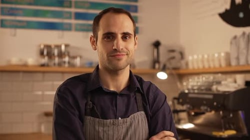 Close Up Footage of Smiling Middleaged Caucasian Male Barista Standing with Folded Hands Wearing
