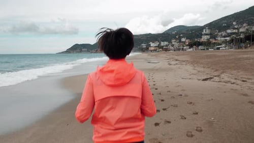 Young woman is running on beach in the morning.