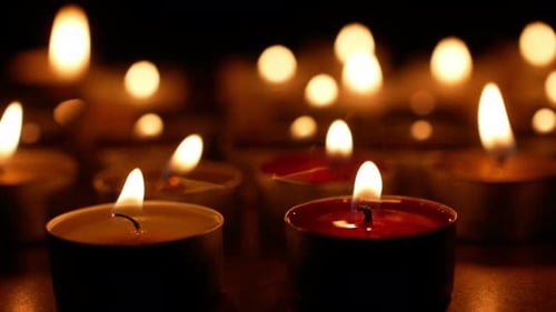 Glowing Candles Flickering in the Dark Close Up