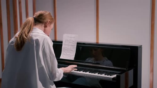 Woman sensually playing the piano view from the back