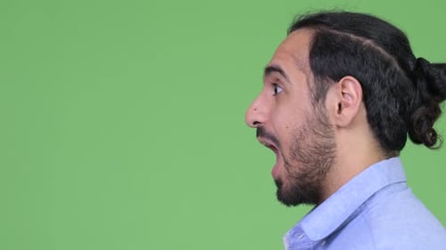 Profile View of Young Handsome Bearded Indian Businessman Shouting in Surprise