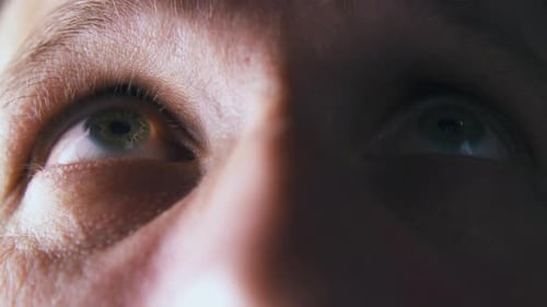 Person Looks Up and Straight with Green Eye in Shadow