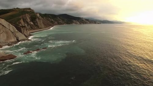 Stormy sea waves splashing on rocky cliff