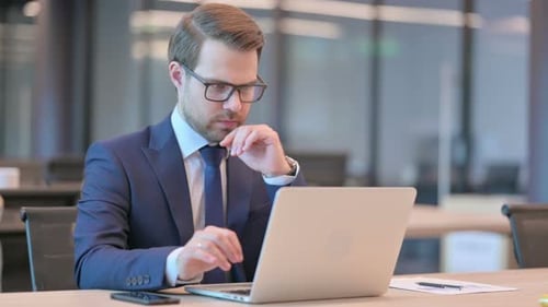 Businessman with Laptop Thinking at Work