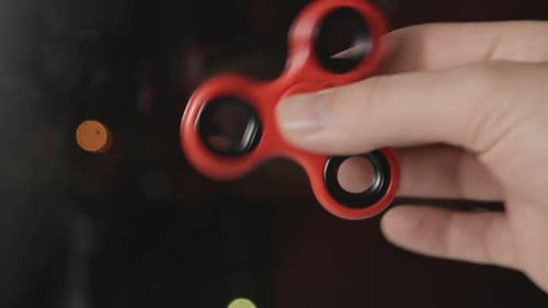 Hand Spinning Red Fidget Spinner at Night