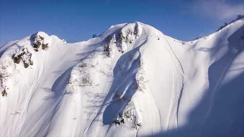 Un hélicoptère atterrit pour embarquer des skieurs en montagne.