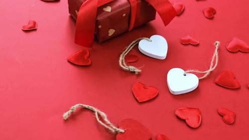 Gift Box with Hearts Decorations on Red Background