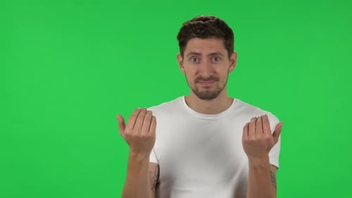 Portrait of Confident Guy Is Waving Hand and Showing Gesture Come Here. Green Screen