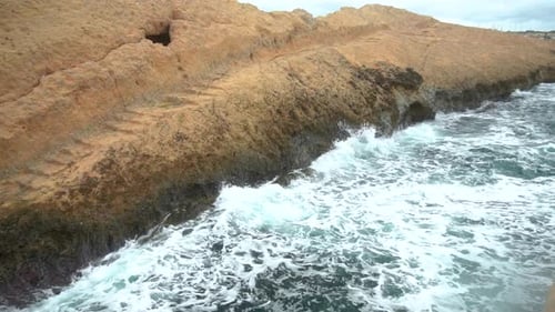 Die Wellen schlagen gegen die Felsen. Sturm auf dem Mittelmeer. Das Meer ist türkis. Zeitlupe.