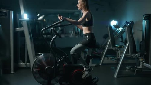A Pretty Athletic Fit Woman is Doing Exercise on a Fitness Machine in the Gym Training Full Body
