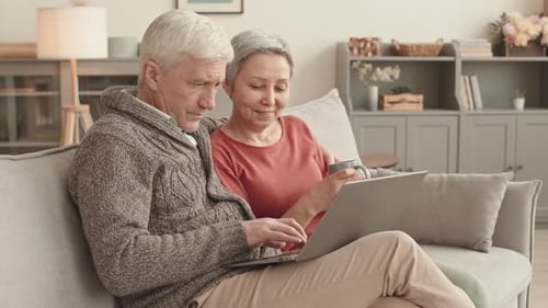 Senior Couple Using Laptop Together on Couch