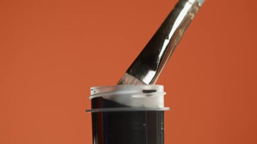 Black Paint Isolated on Orange Background