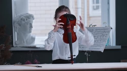 Young Girl Playing Violin Indoors During the Day