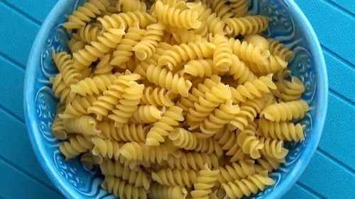 Overhead View of Uncooked Rotini Pasta in Blue Bowl