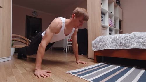 Young Man Doing Push-ups in Bedroom