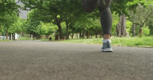 Seção baixa de mulher correndo no parque