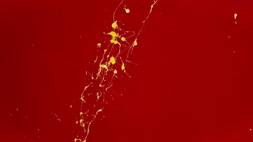 Des éclaboussures de peinture jaune vif sur le mur rouge vif