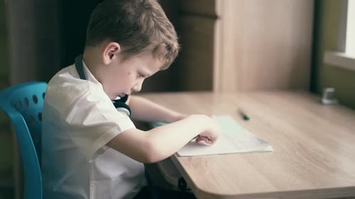 Child Sit in Headphones and Do School Homework