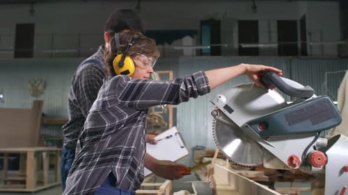 Workers Using Circular Saw in Carpentry Shop