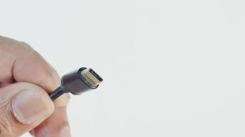 Hand Holding Black USB-C Cable in Bright Studio