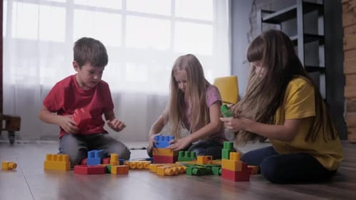 Children Playing with Colorful Building Blocks on Floor